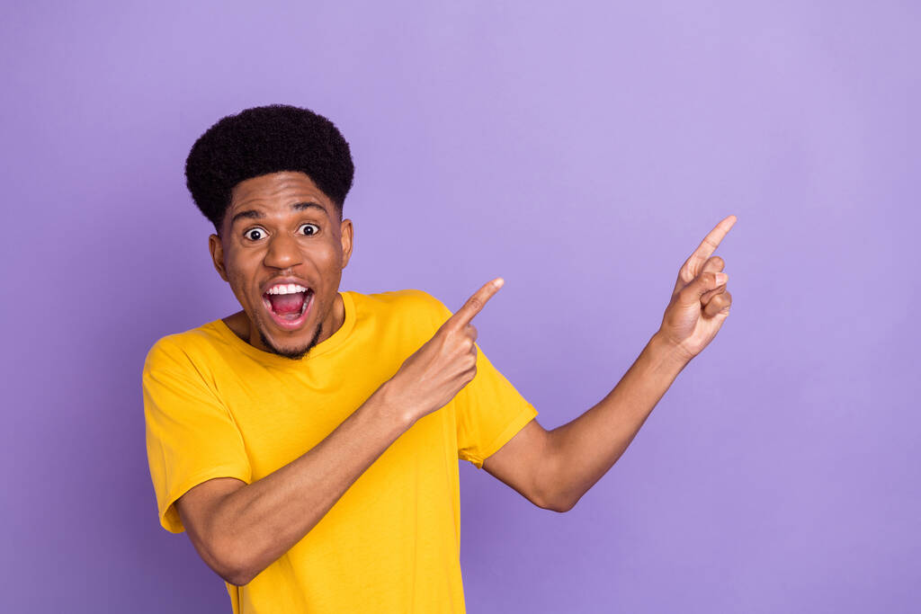 Portrait of attractive amazed cheerful guy demonstrating copy space place solution isolated over violet purple color background - Photo, Image