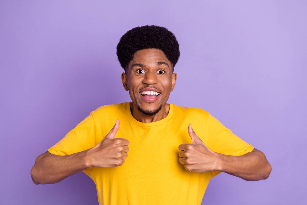 Фото веселой молодой темной кожи счастливый человек сделать большие пальцы вверх рекомендовать изолированы на фиолетовом фоне цвета - Фото, изображение