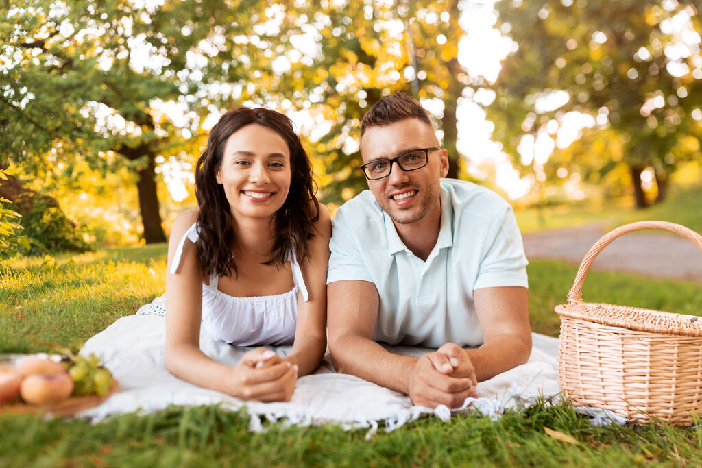 pareja feliz en manta de picnic en el parque de verano - Foto, Imagen