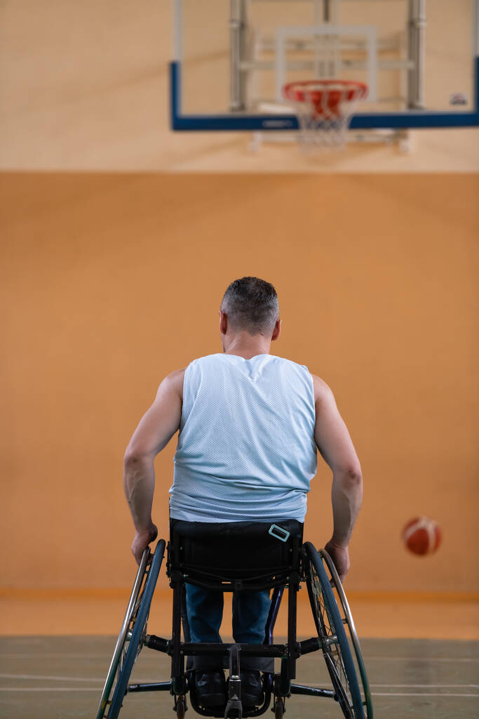 válka invalidní ve vozíčku s míčem v basketbalovém klubu při tréninku s profesionálním sportovním vybavením pro tělesně postižené. pojetí sportu pro osoby se zdravotním postižením - Fotografie, Obrázek
