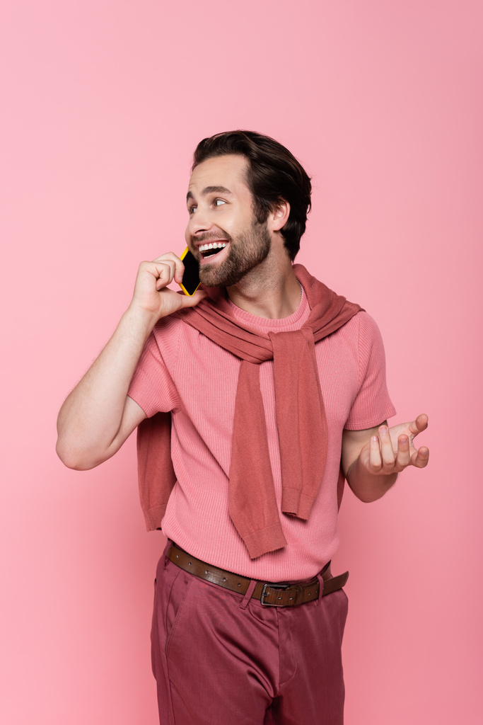 Uomo positivo in t-shirt che parla su smartphone isolato su rosa  - Foto, immagini