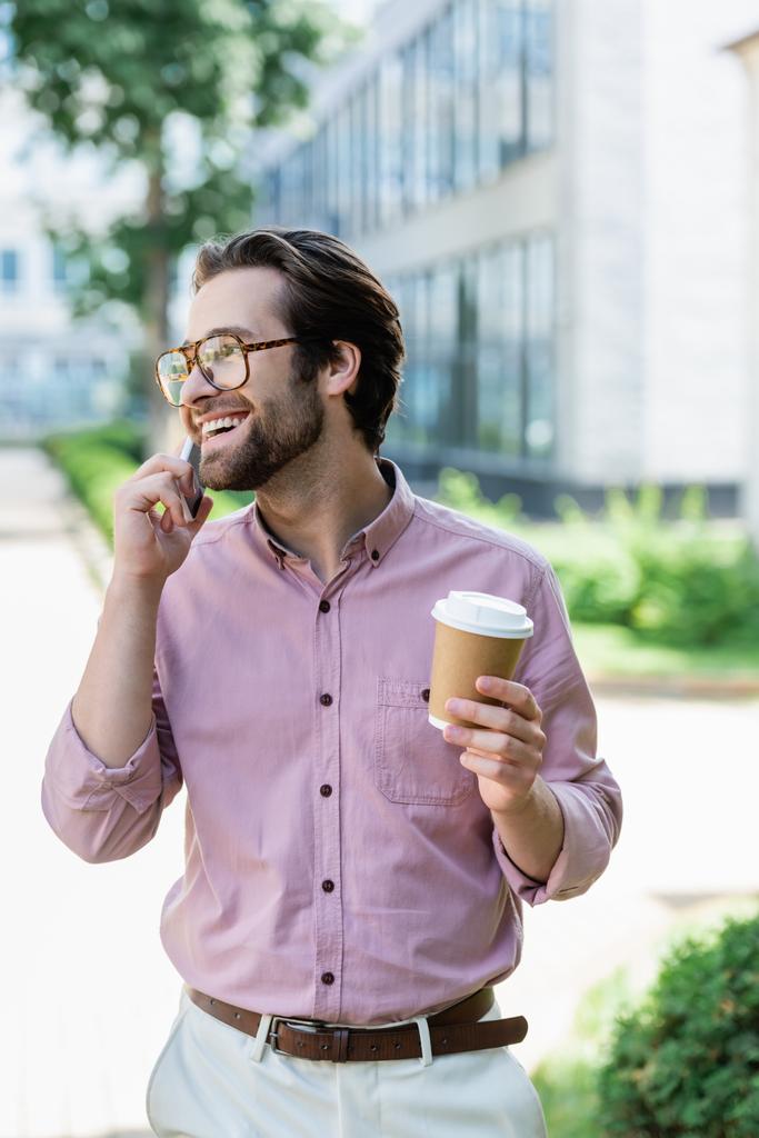 Lächelnder Geschäftsmann mit Kaffee zum Telefonieren  - Foto, Bild