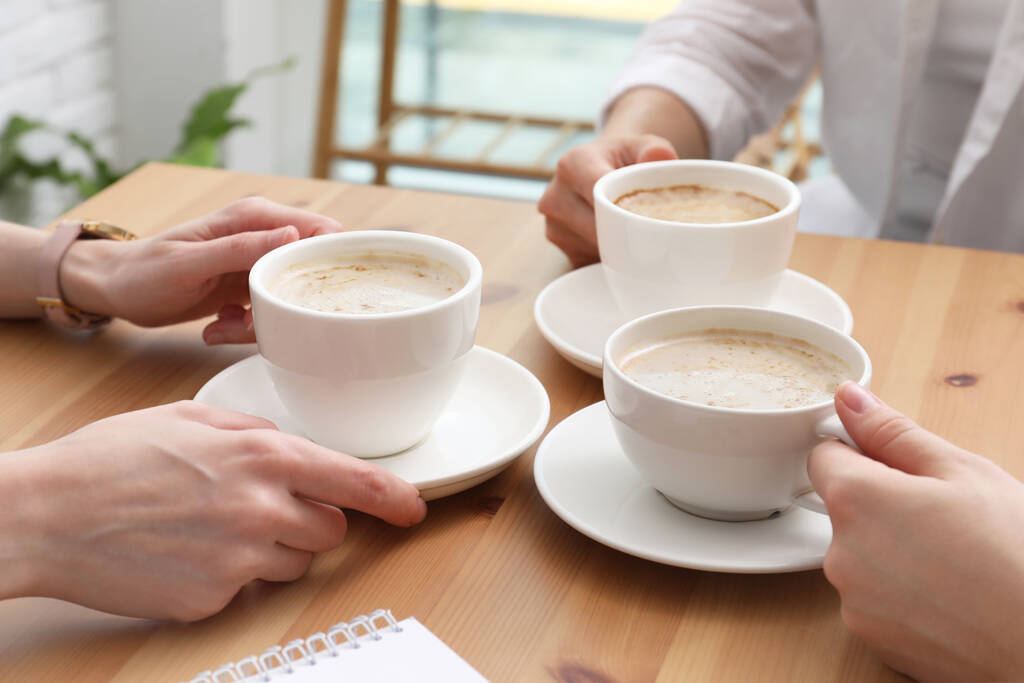 Mulheres com xícaras de café à mesa no café, close-up - Foto, Imagem