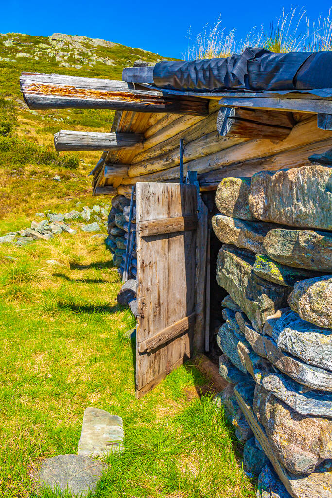 erstaunliche alte Steinhaus am Vavatn Landschaft Panoramablick mit Bergen mit Schnee im Sommer in Hemsedal Norwegen. - Foto, Bild