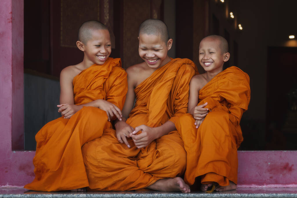 três monge novato budista tailandês sorrindo e sentados juntos no portão do templo  - Foto, Imagem