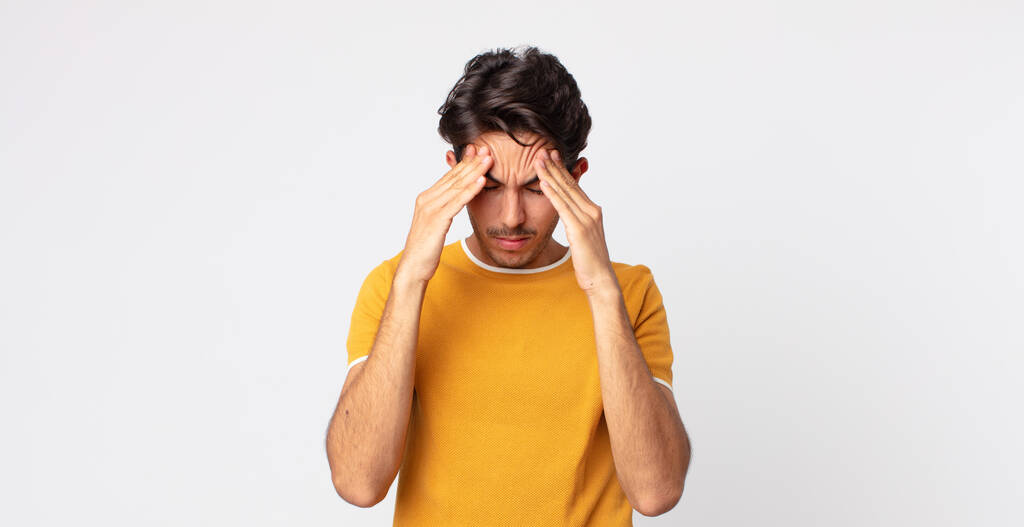 hispánec pohledný muž vypadá vystresovaný a frustrovaný, pracuje pod tlakem s bolestí hlavy a trápí se problémy - Fotografie, Obrázek