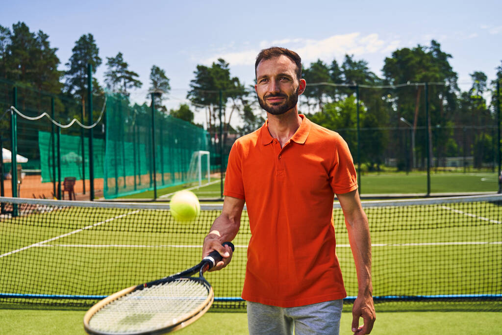 Mies aloittelija tennispelaaja hallitsee palvella tekniikkaa - Valokuva, kuva