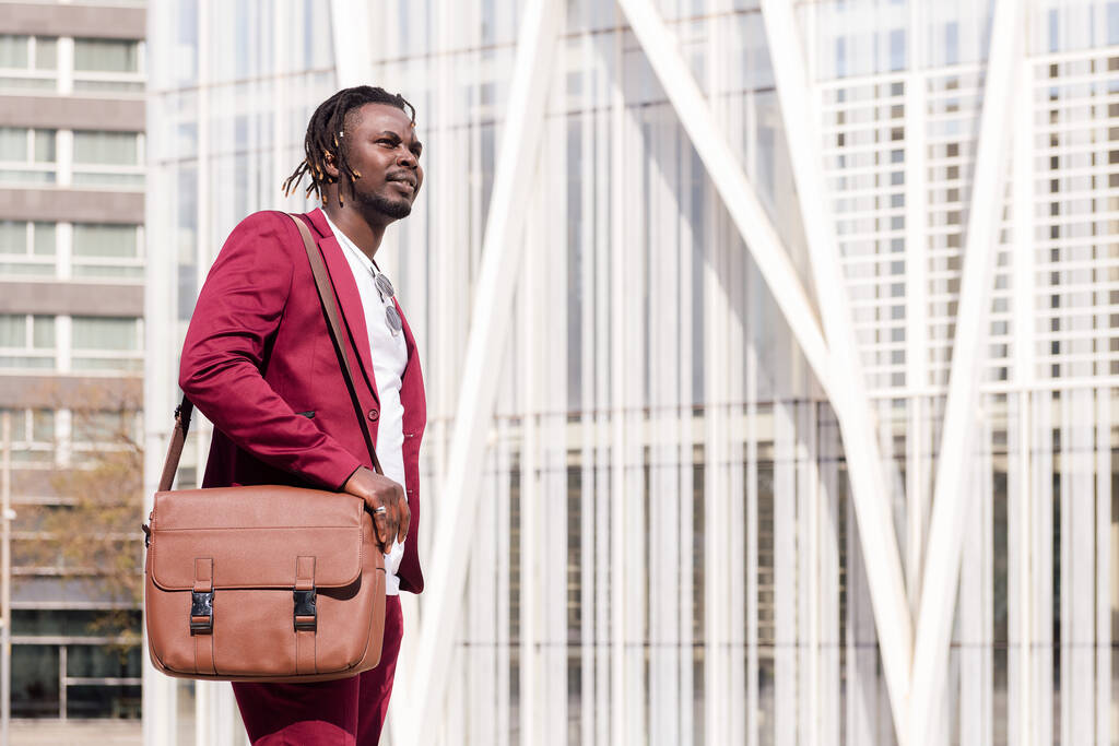 elegante Afrikaanse zakenman met aktetas loopt door de stad financiële centrum, kopieer ruimte voor tekst - Foto, afbeelding