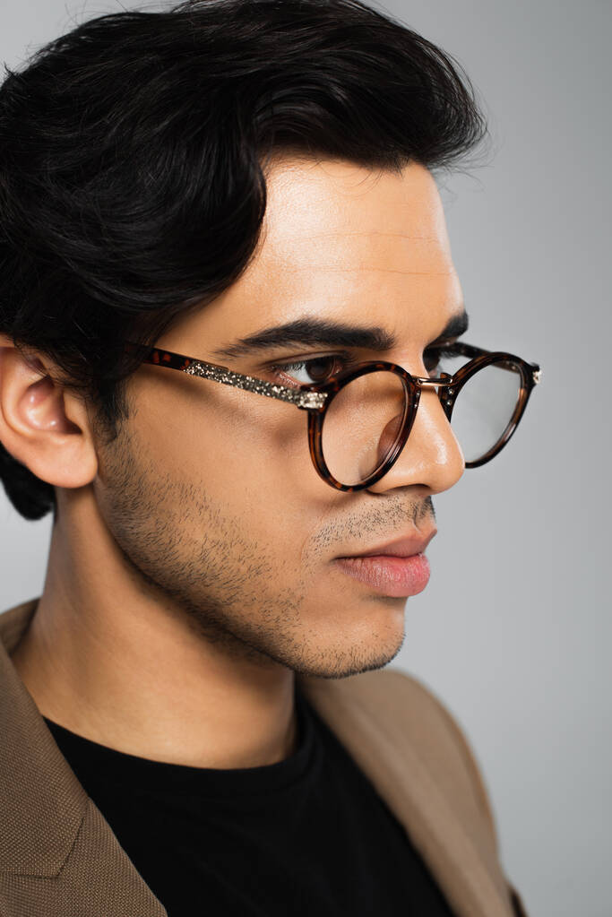 портрет молодого чоловіка в стильних окулярах позує ізольовано на сірому
  - Фото, зображення