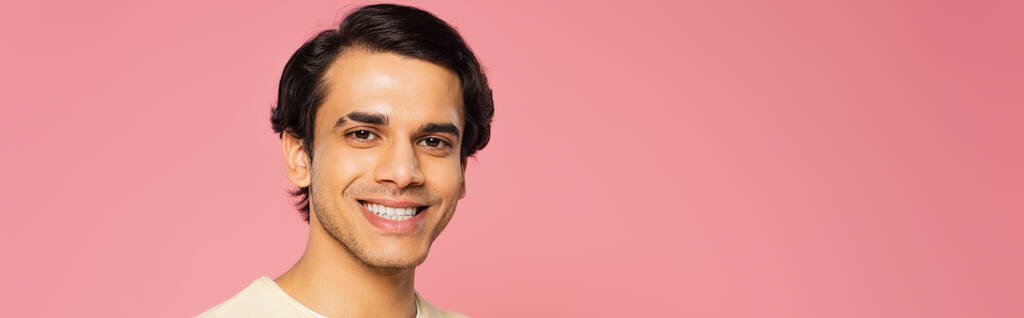 heureux jeune homme regardant caméra et souriant isolé sur rose, bannière - Photo, image