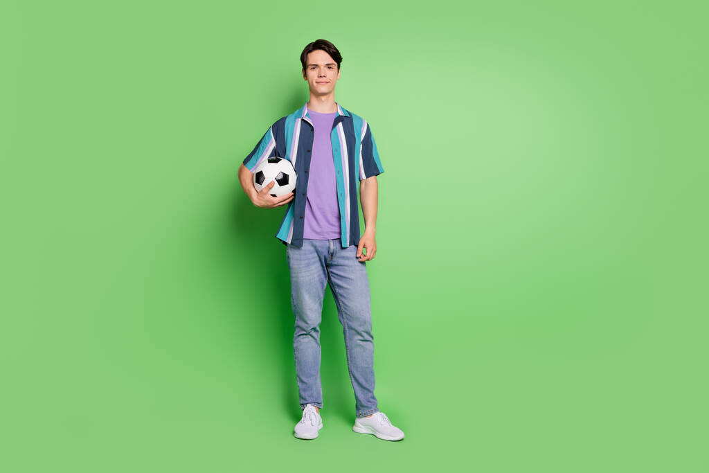 Foto de cuerpo entero de joven feliz positivo cogido de la mano jugador de fútbol deporte aislado sobre fondo de color verde - Foto, Imagen