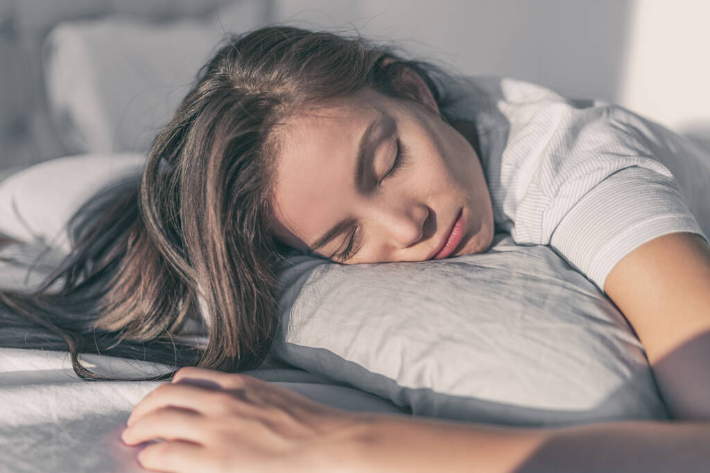 Fáradt nő szomorú fekszik az ágyban depressziós alszik sírva a párnán. Ázsiai lány vicces arc beteg vagy boldogtalan szunyókál otthon - Fotó, kép