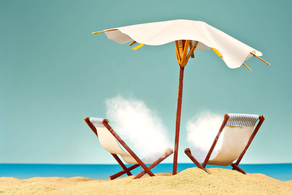 Sonnenschirme und Liegestühle im Sand. Weiße Wolken sonnen sich am Strand. Papierschirme für Cocktails im Hintergrund. das Konzept der Erholung, des Meeres und des Urlaubs. - Foto, Bild