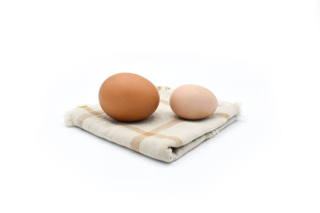 Сравниваю стандартное куриное яйцо и яйцо бантам. Изолированные на белом. - Фото, изображение