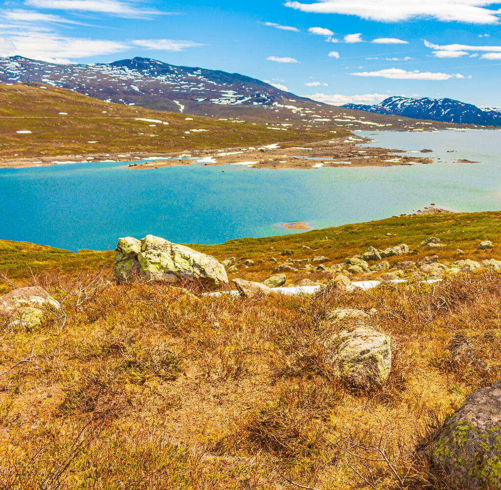 Удивительная панорама озера Ваватн грубый пейзаж скалы валуны и горы со снегом летом в Хемседал Норвегия. - Фото, изображение