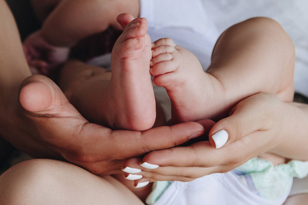 Anne ve baba ellerinde bebek ayakları tutuyor. - Fotoğraf, Görsel
