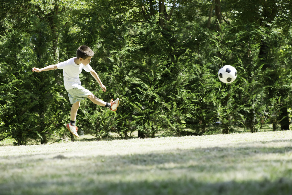 Child playing football in a stadium - Photo, Image