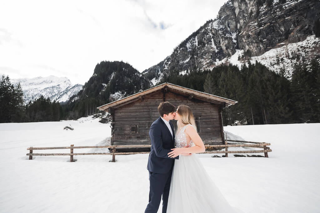 若い幸せなカップルキス、背景に雪の中の山の風景 - 写真・画像