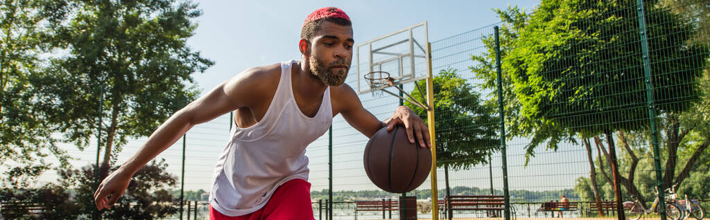Fiatal afro-amerikai férfi kosárlabdázik a szabadban, banner  - Fotó, kép
