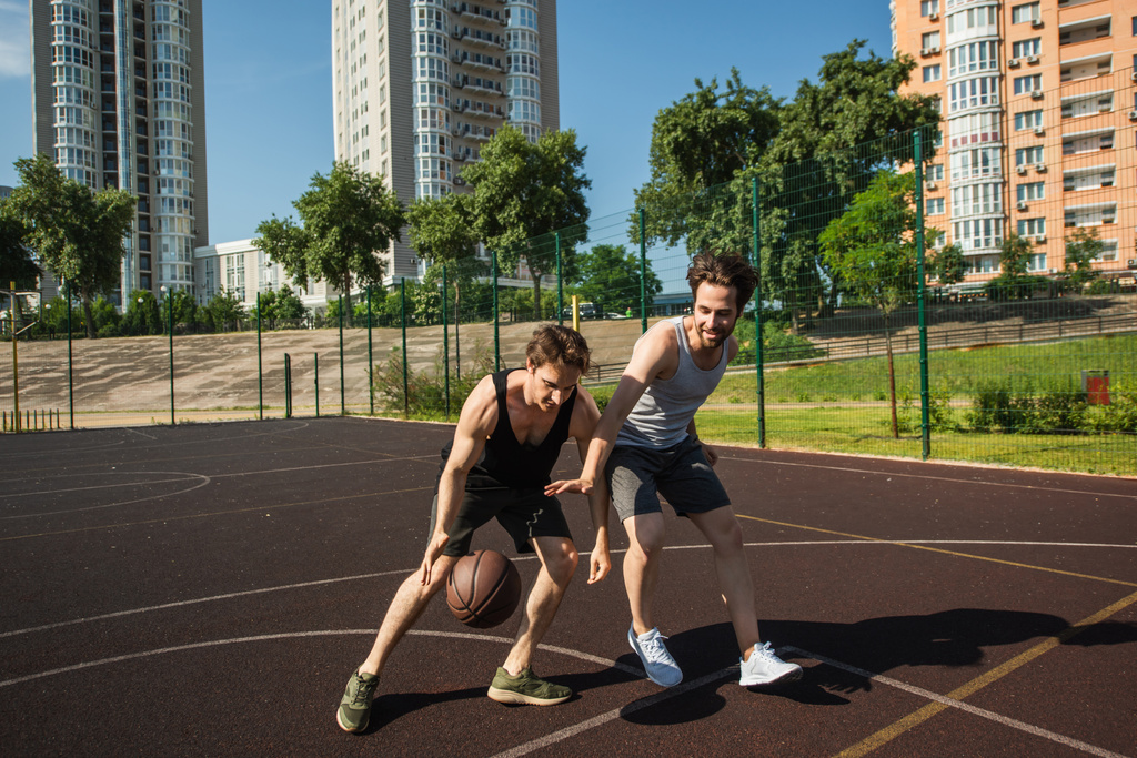遊び場でバスケットボールをしながら若い男性のトレーニング  - 写真・画像