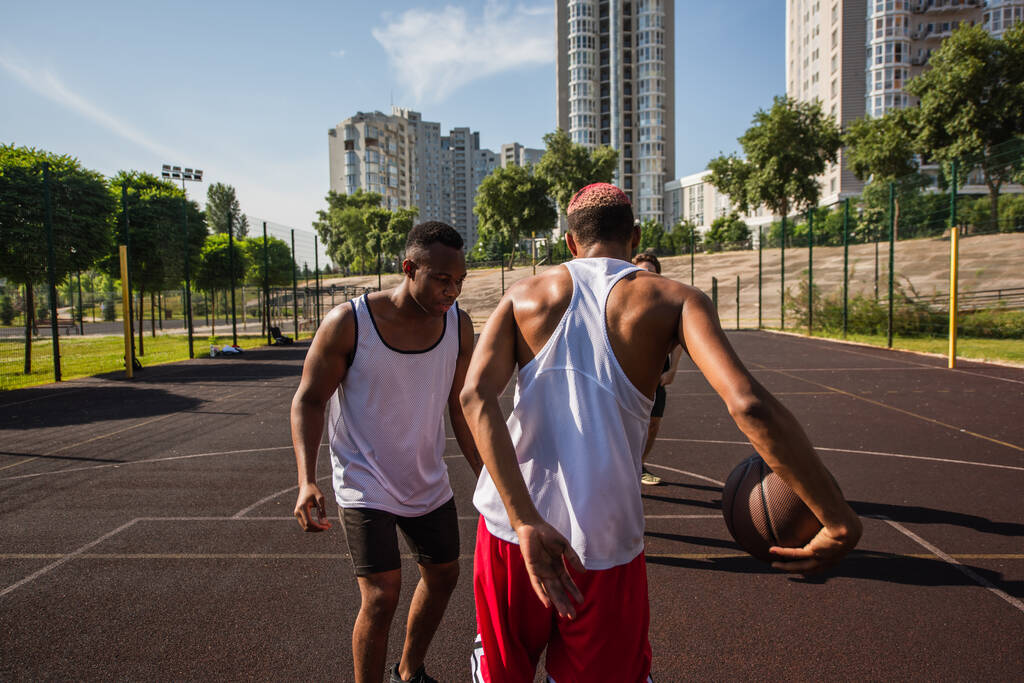Dışarıda arkadaşlarıyla sokak basketbolu oynayan Afrikalı bir Amerikalı.  - Fotoğraf, Görsel