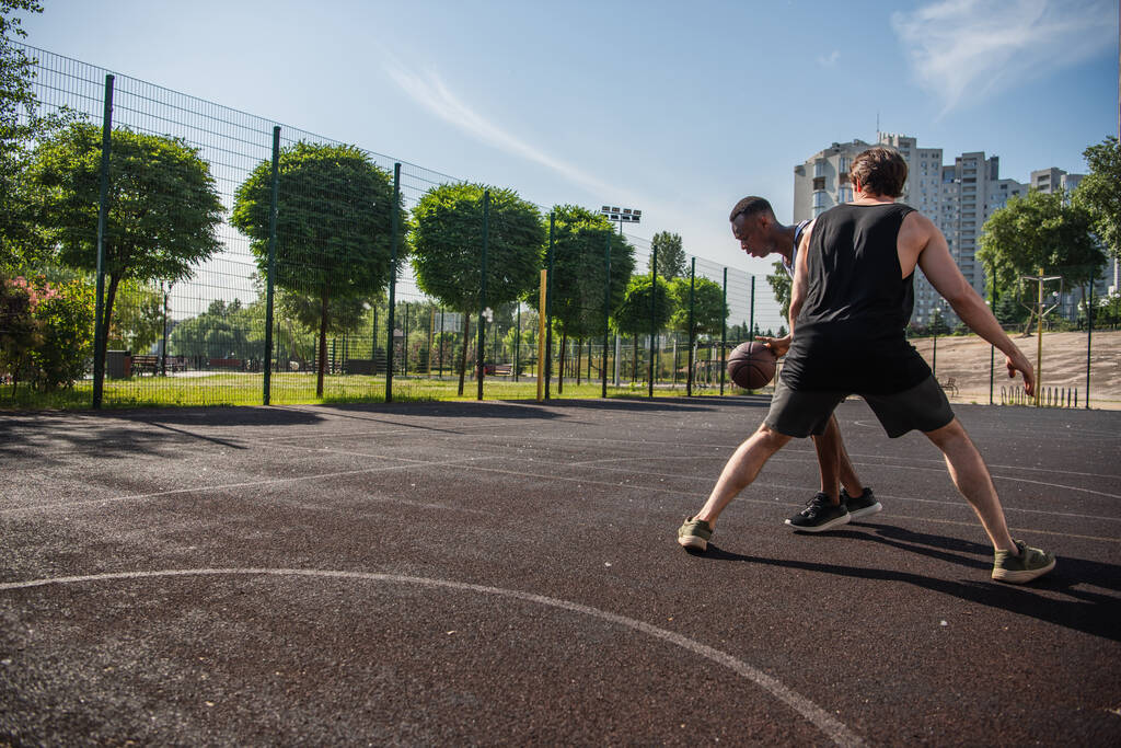 Interracial sportolók edzés közben kosárlabda szabadban  - Fotó, kép