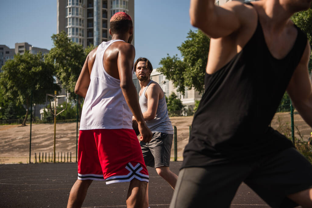 バスケットボールの試合中にボールと友達に近いアフリカ系アメリカ人のスポーツマン  - 写真・画像