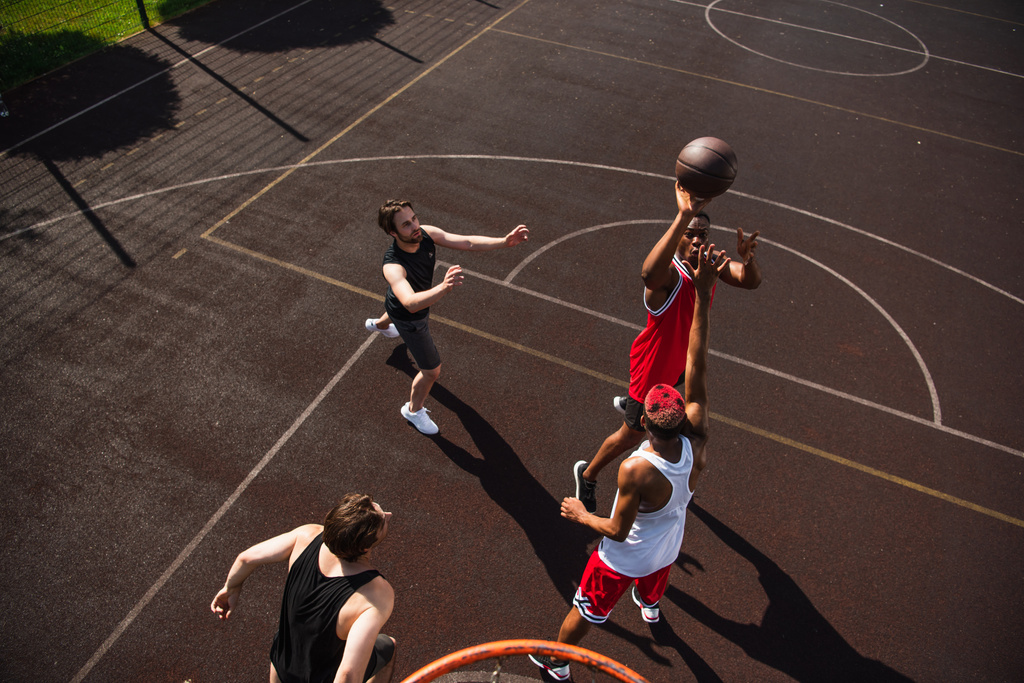 Вигляд африканського американця, який грає в баскетбол з друзями.  - Фото, зображення