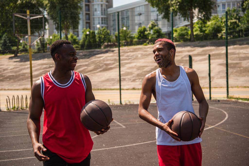 アフリカ系アメリカ人バスケットボール選手の遊び場を歩く笑顔  - 写真・画像