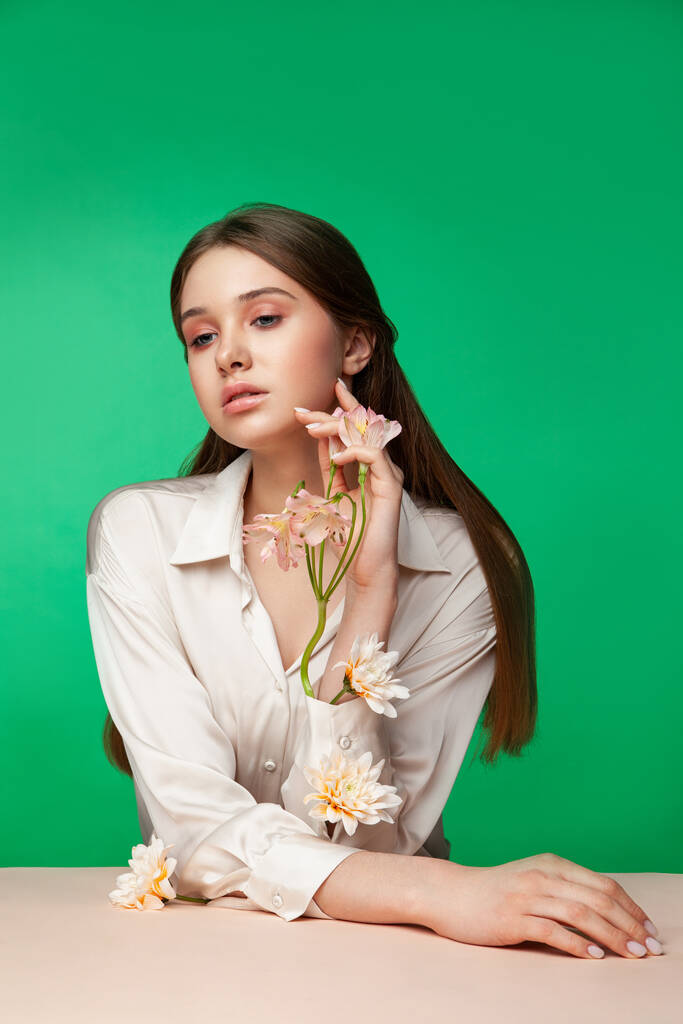 Jonge vrouw met bloemen in blouse mouwen - Foto, afbeelding