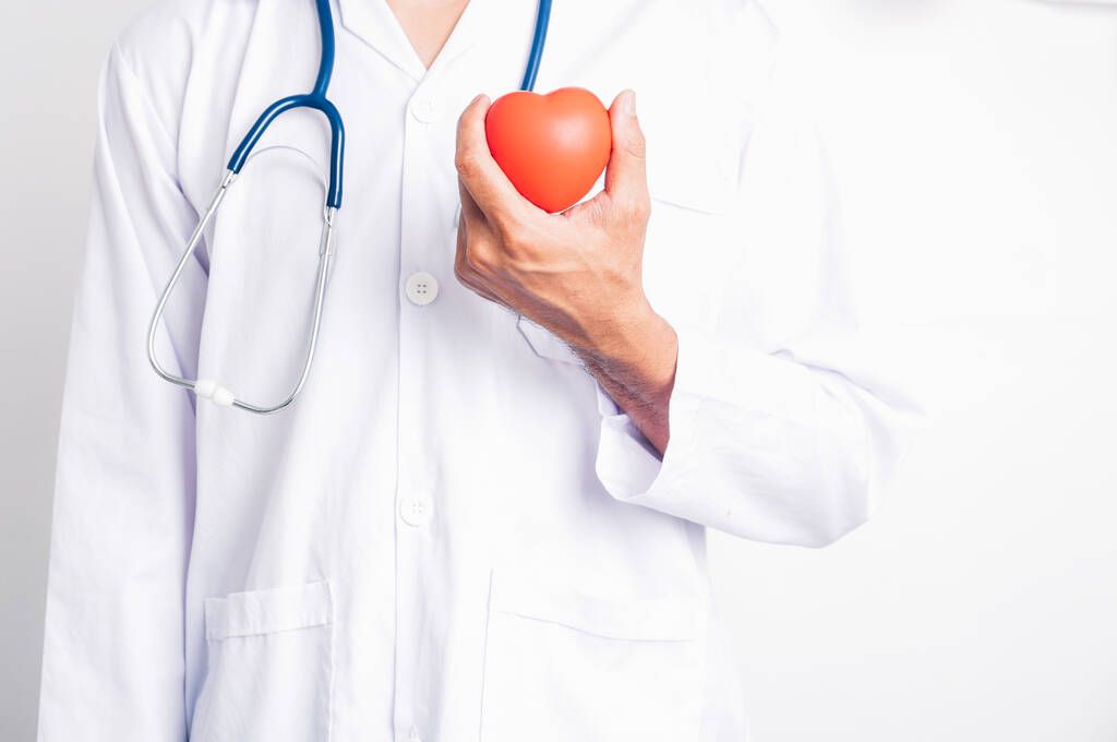 Nahaufnahme Mann Arzt mit Stethoskop er hält rotes Herz auf der Hand isolieren auf weißem Hintergrund - Foto, Bild