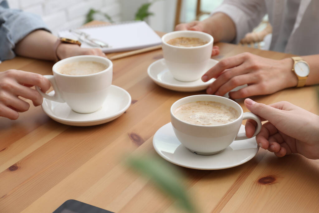 Las mujeres con tazas de café en la mesa en la cafetería, primer plano - Foto, imagen