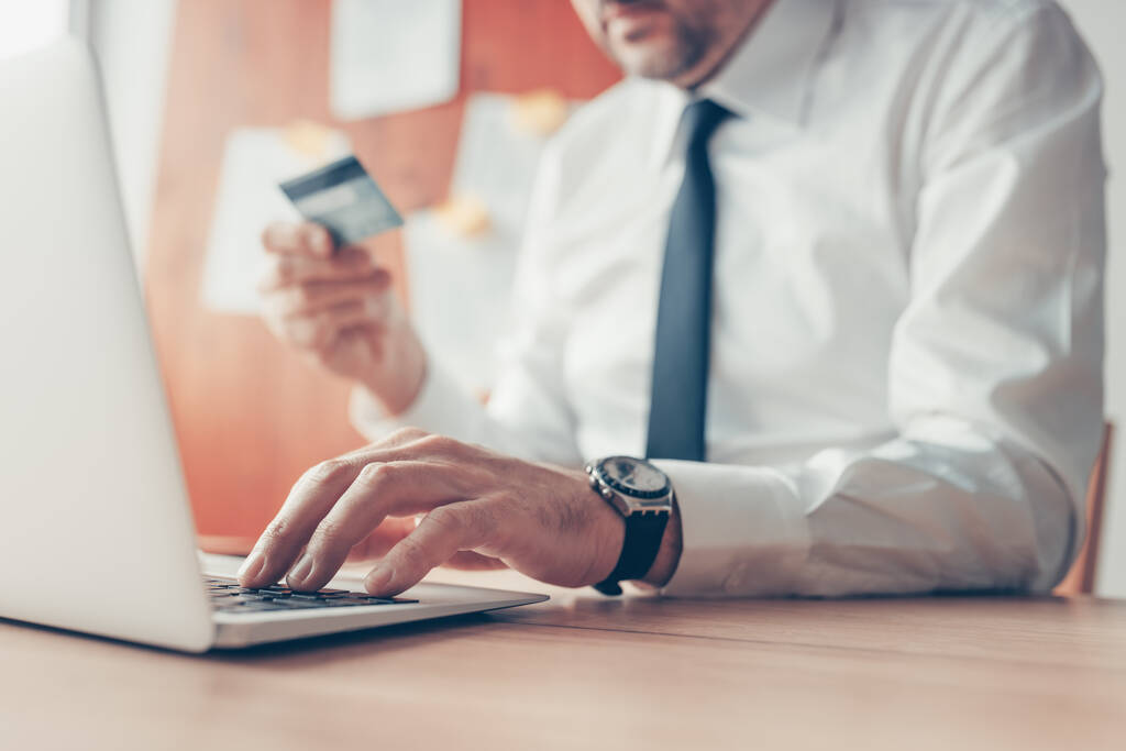 Homme d'affaires effectuant une transaction bancaire en ligne à l'aide d'un ordinateur portable et d'une carte de crédit, objectif sélectif - Photo, image