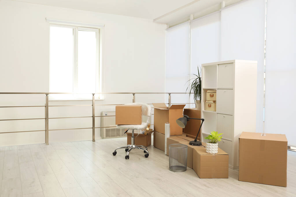 Картонные коробки с упакованными вещами в новом офисе, место для смс. День переезда - Фото, изображение