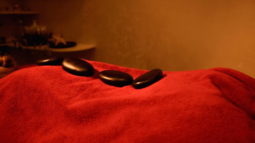 pierres chaudes sur le dos du client couché sur la table de massage  - Photo, image
