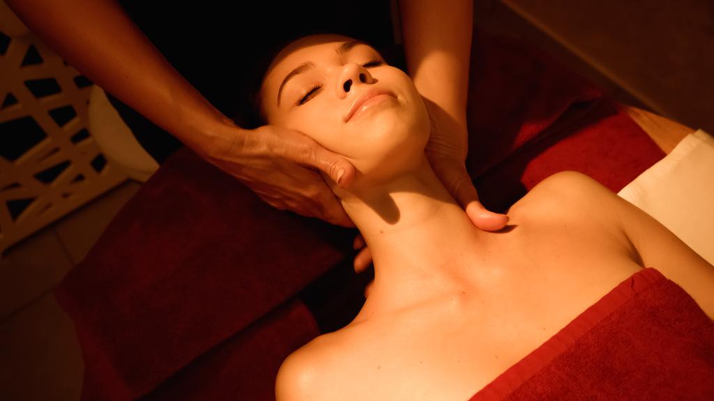 mujer con los ojos cerrados recibiendo masaje en el cuello de masajista profesional en el salón de spa - Foto, Imagen