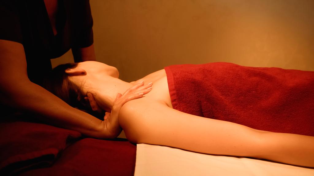 женщина получает массаж шеи от профессионального массажиста в спа-салоне - Фото, изображение