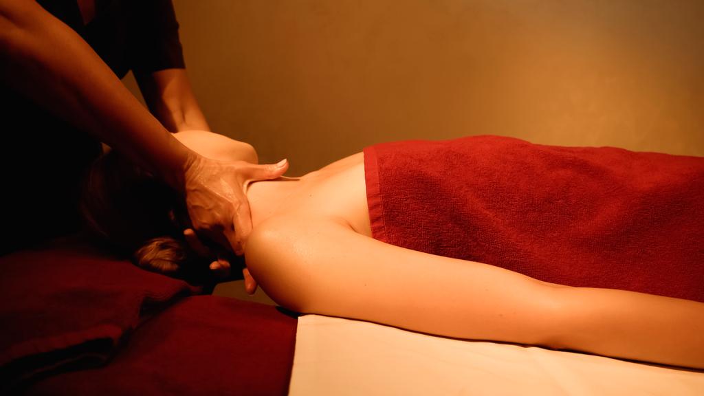 mladá žena dostává masáž šíje od profesionálního maséra v lázeňském salonu - Fotografie, Obrázek