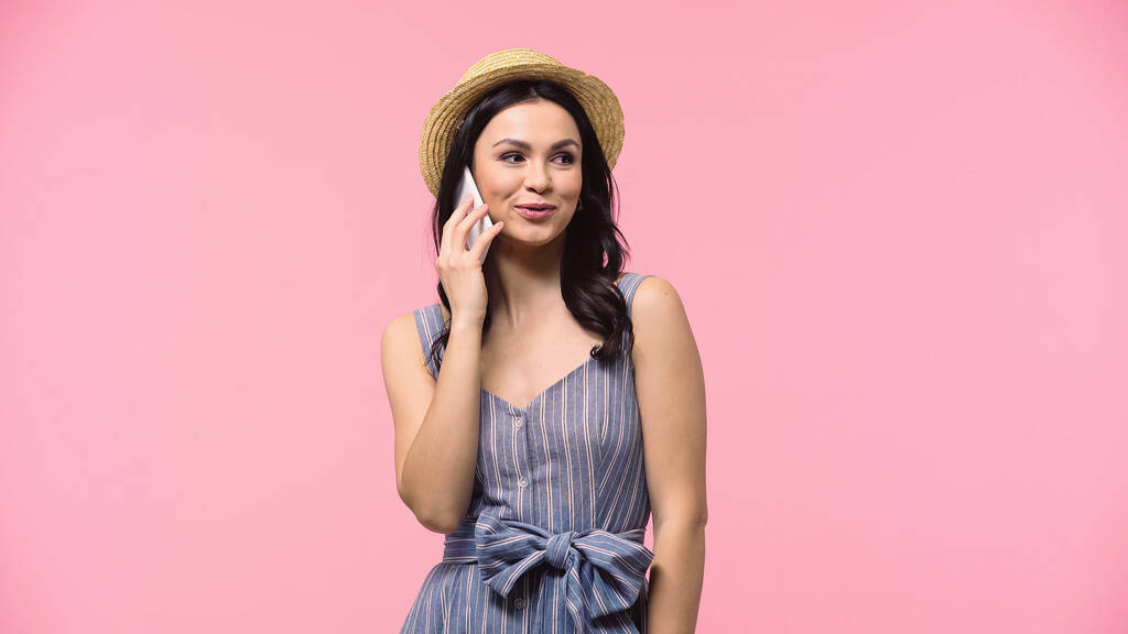 Young woman in sun hat talking on mobile phone isolated on pink  - Photo, Image