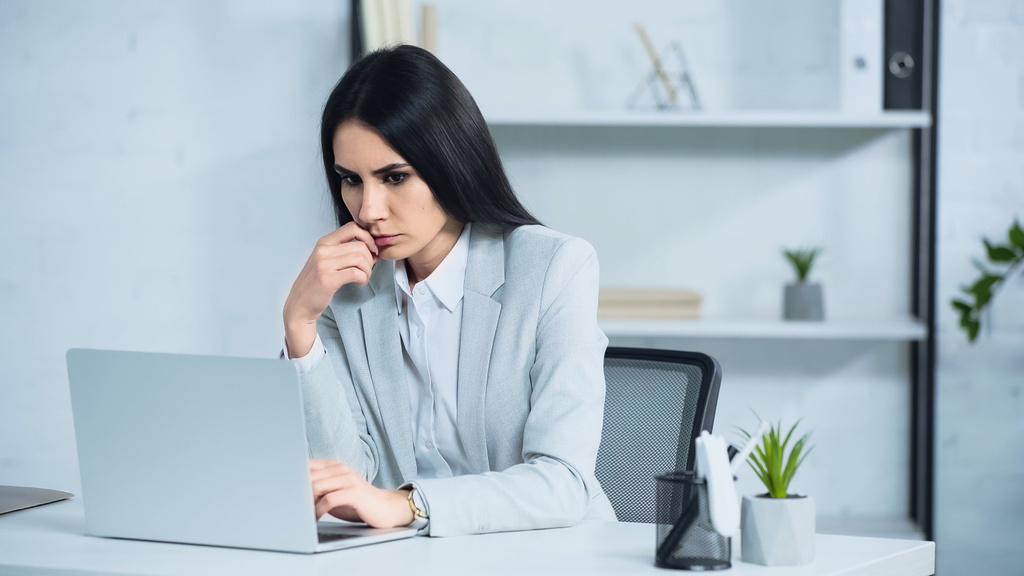 беспокойная деловая женщина с ноутбуком в офисе  - Фото, изображение