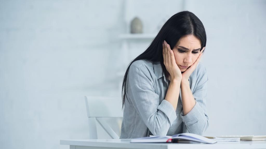 stressed woman sitting near calculator on desk - Photo, Image