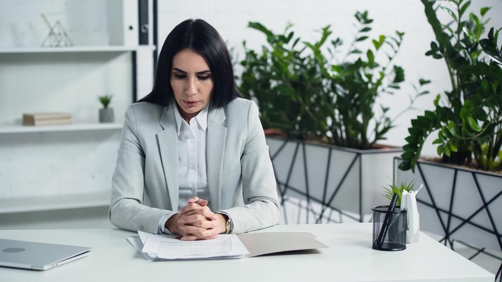 displeased businesswoman breathing and looking at documents in office  - Photo, Image