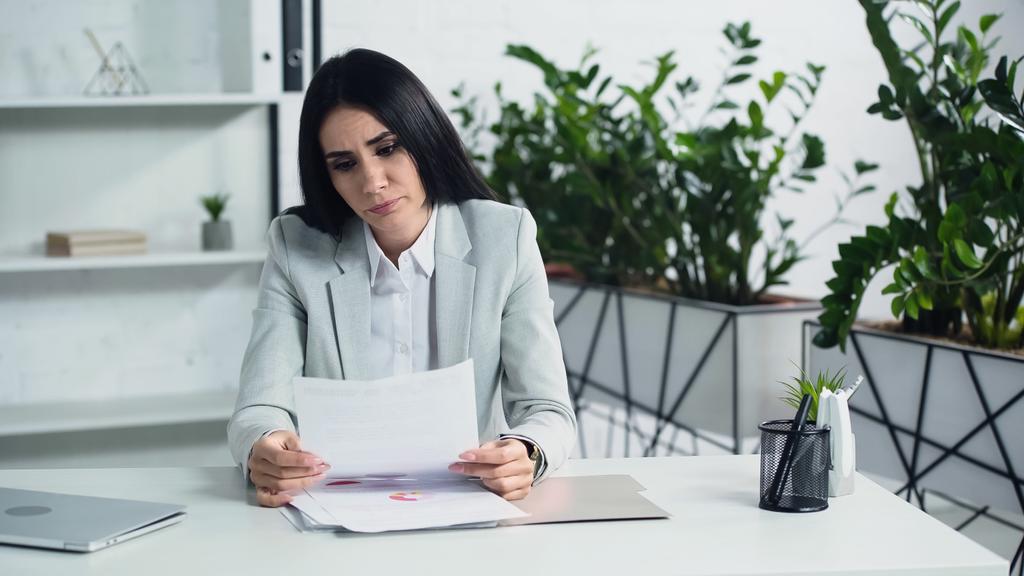 mujer de negocios insatisfecha mirando el documento en la oficina  - Foto, Imagen