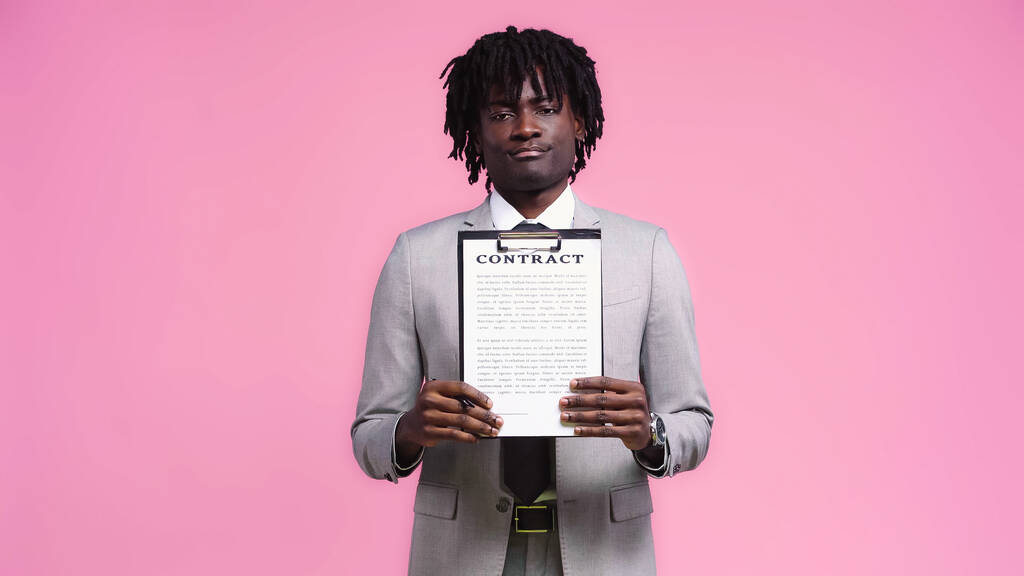 Afrykański amerykański biznesmen pokazuje kontrakt odizolowany na różowy - Zdjęcie, obraz