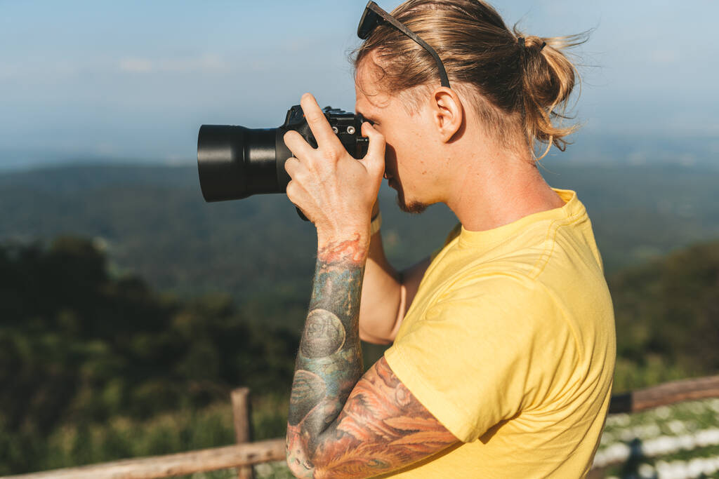 Homme photographe en tshirt jaune faisant la photo de beaux paysages dans le nord de Chiang Mai - Photo, image
