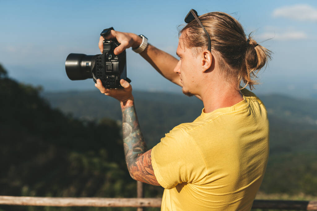 Hombre fotógrafo en camiseta amarilla haciendo foto de hermoso paisaje en el norte de Chiang Mai - Foto, Imagen
