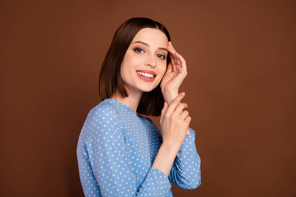 Photo de belle coiffure courte jeune dame toucher visage porter blouse bleue isolé sur fond de couleur marron - Photo, image