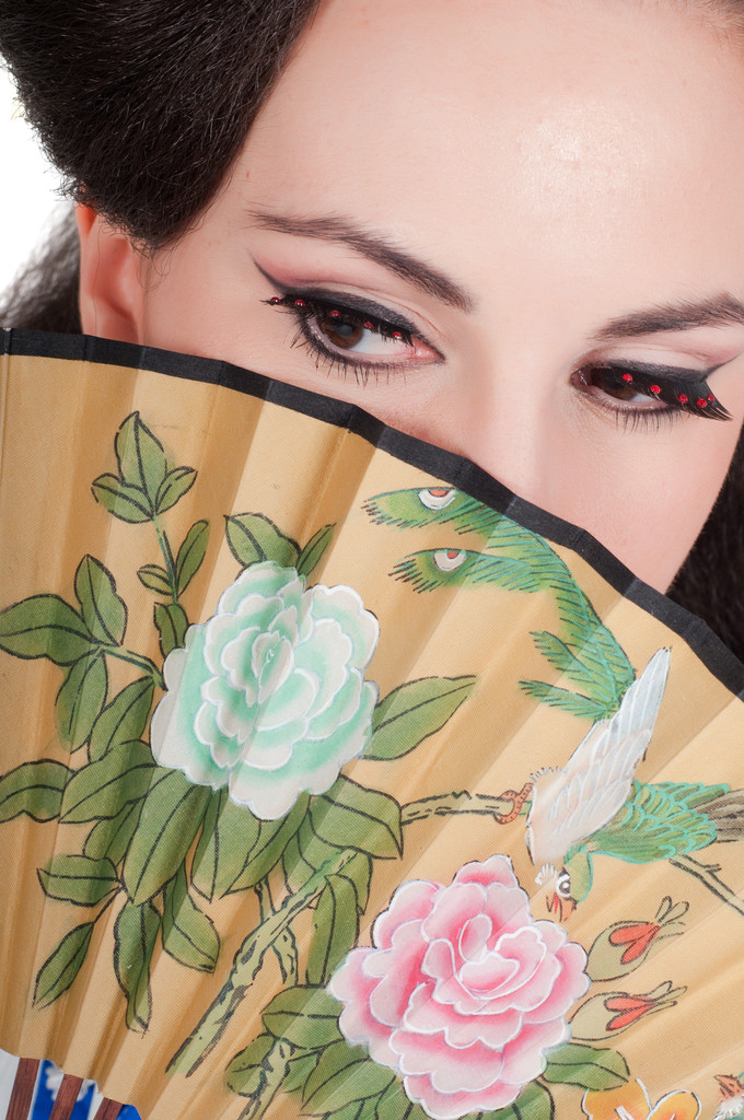 προσωπογραφία του κοριτσιού από την ασιατική εμφάνιση με ένα make-up υπό το geisha σε λευκό φόντο - Φωτογραφία, εικόνα
