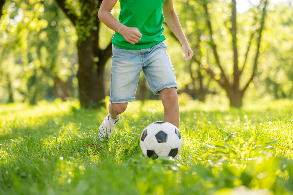 Criança júnior jogando futebol no gramado verde - Foto, Imagem