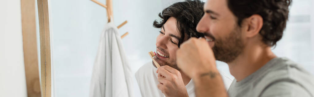счастливая гей пара чистить зубы в ванной комнате, баннер - Фото, изображение